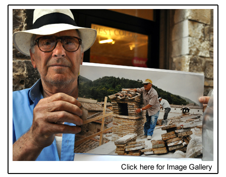 Ezio Martinelli holds a picture of himself repairing a chimney at 82.